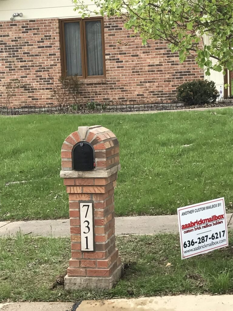 Arched multicolor brick mailbox with a stone keystone, mailbox door open showing the red flag